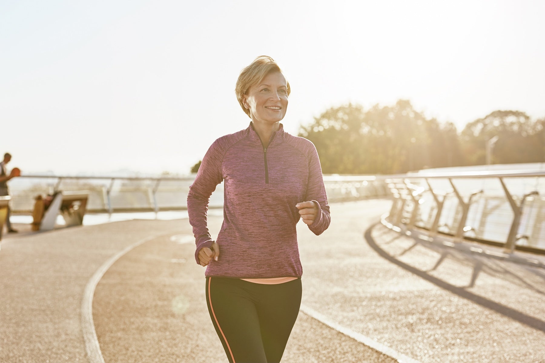 Happy motivated mature woman running outdoors — HDAAs and electrolytes for replenishing more than just fluids in active women 40+