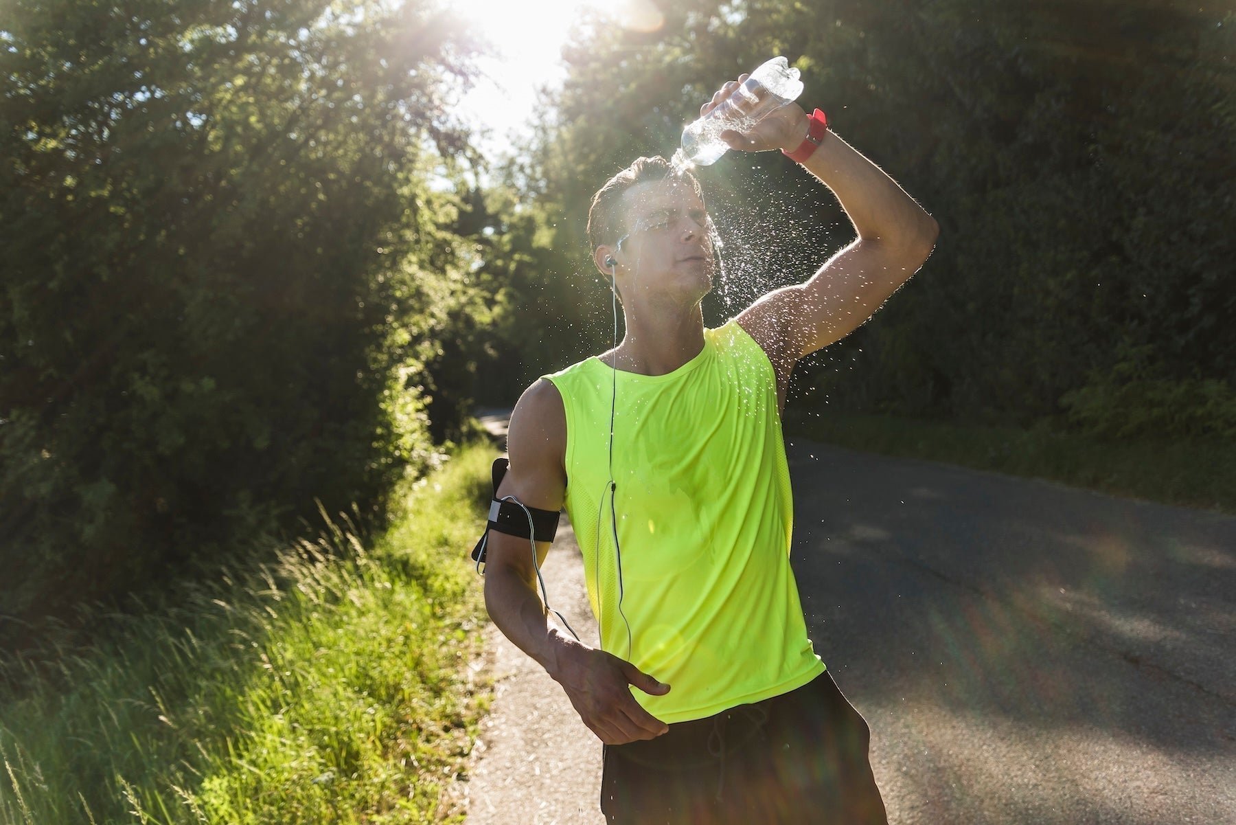 Jogger pouring water over face in the park — why HDAAs are essential for exercise recovery beyond electrolytes alone