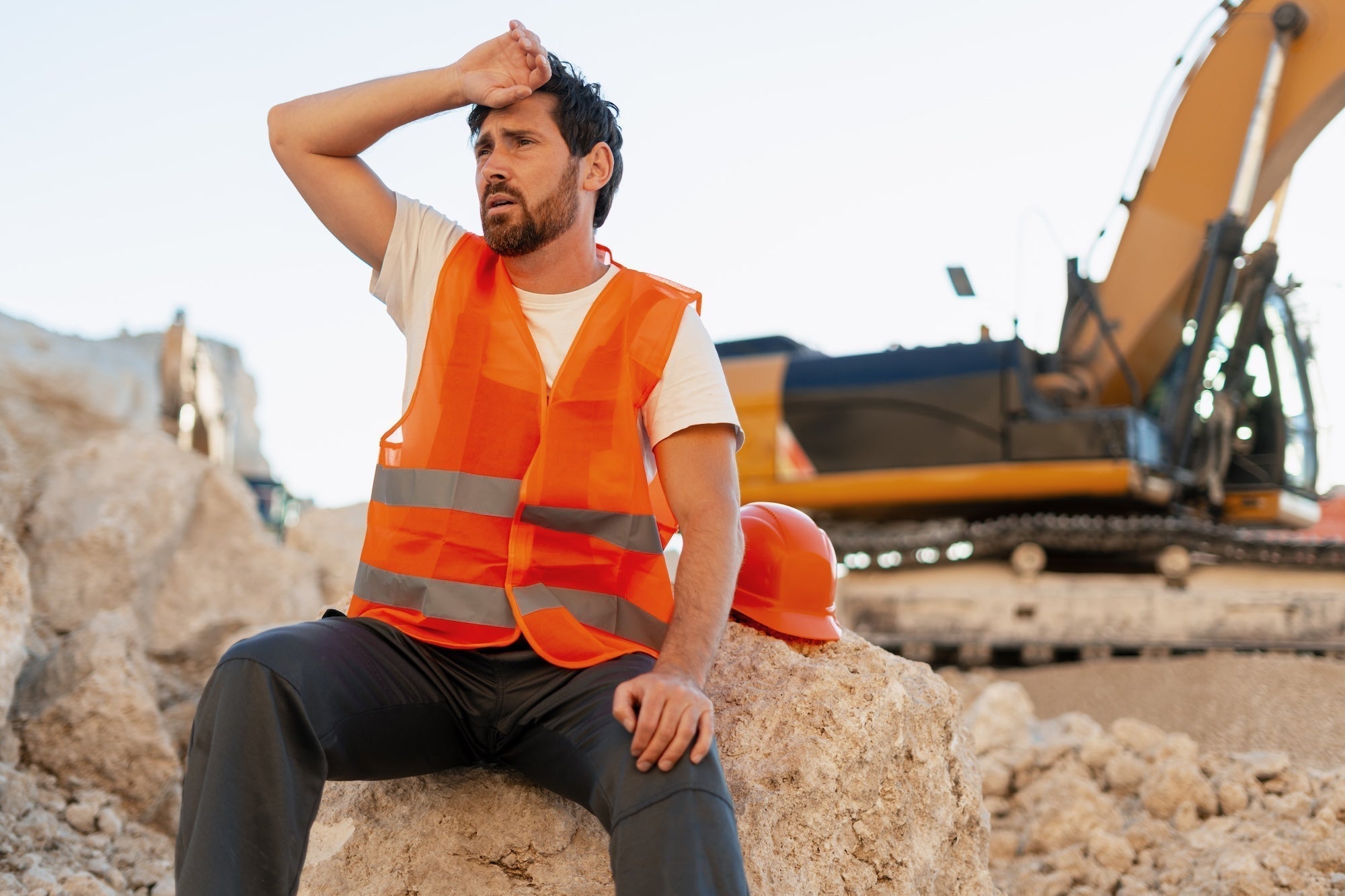 Tired tradesman in safety vest resting during hot conditions — heat hacks for hydration and HDAA nutrition on hard work days