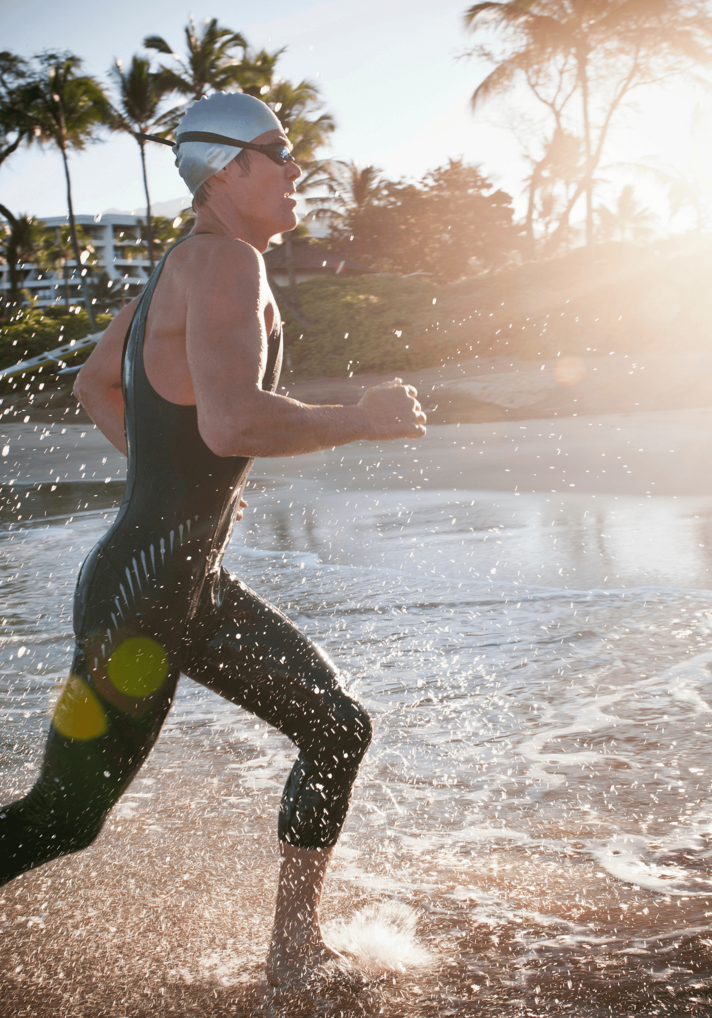 Person running out of a body of water with palm trees in the background