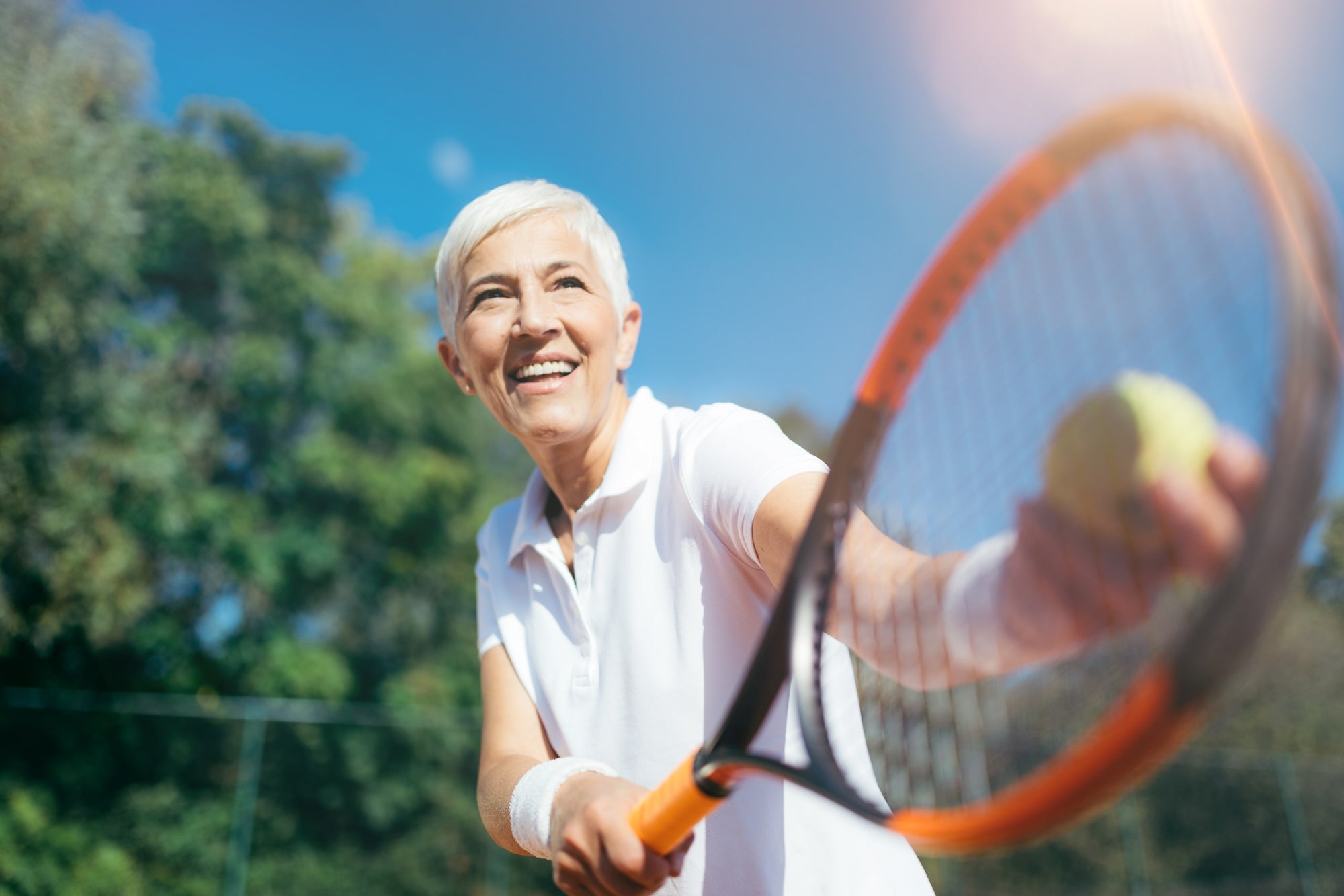 Senior woman playing tennis on a sunny day