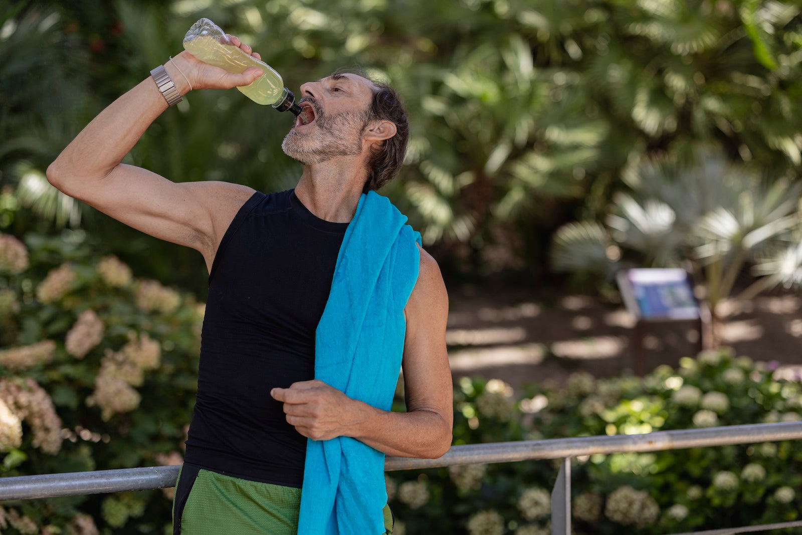 Mature male athlete resting and rehydrating after outdoor exercise — HDAA post workout recovery drink for heat and performance